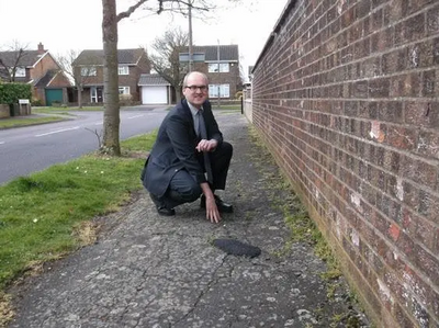 Cllr Michael Headley at a pavement to be resurfaced