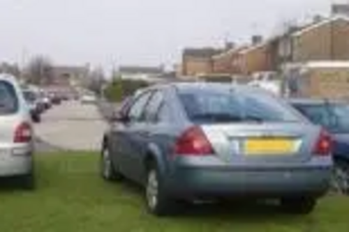 Cars parked on grass verge