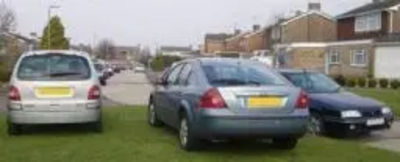 Cars parked on grass verge