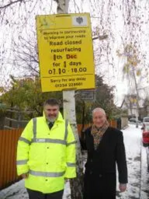 Dave Hodgson and Cllr David Sawyer with St Alban Road resurfacing sign