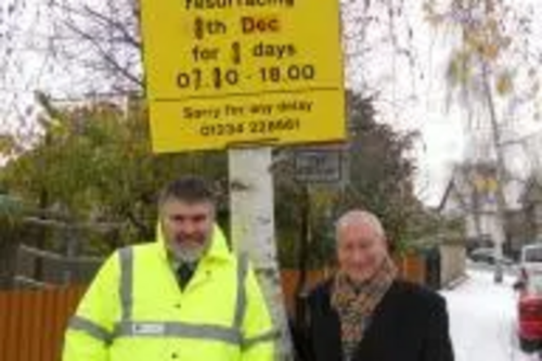 Dave Hodgson and Cllr David Sawyer with St Alban Road resurfacing sign