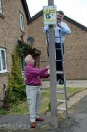 Dave Hodgson and Charles Royden putting up SmartWater signs on lampposts in Brickhill