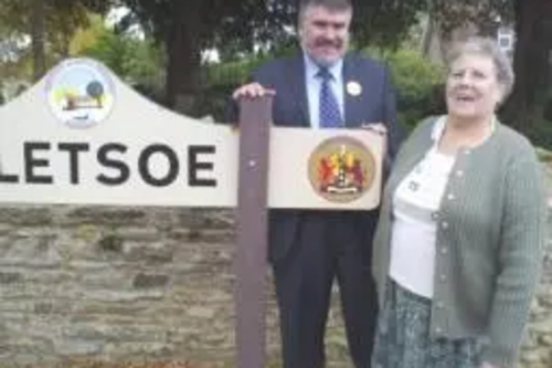 Dave Hodgson with Bletsoe resident Mrs Button at the Bletsoe village sign