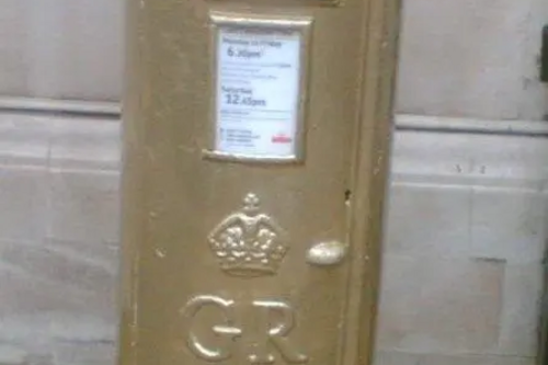 The gold postbox in St Paul's Square, Bedford, painted in honour of Etienne Stott's gold medal at the London 2012 Olympic Games